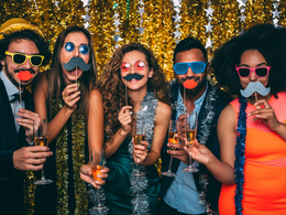 People at a party photobooth using props