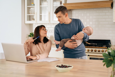 New parents and baby discussing finances