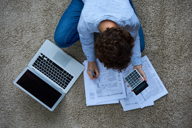 Sitting on floor surrounded by paperwork and laptop
