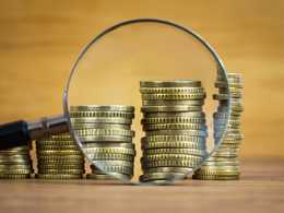 Stacked Gold Coins with Magnifying Glass