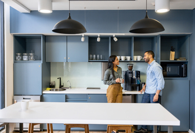 Two coworkers talking in office breakroom